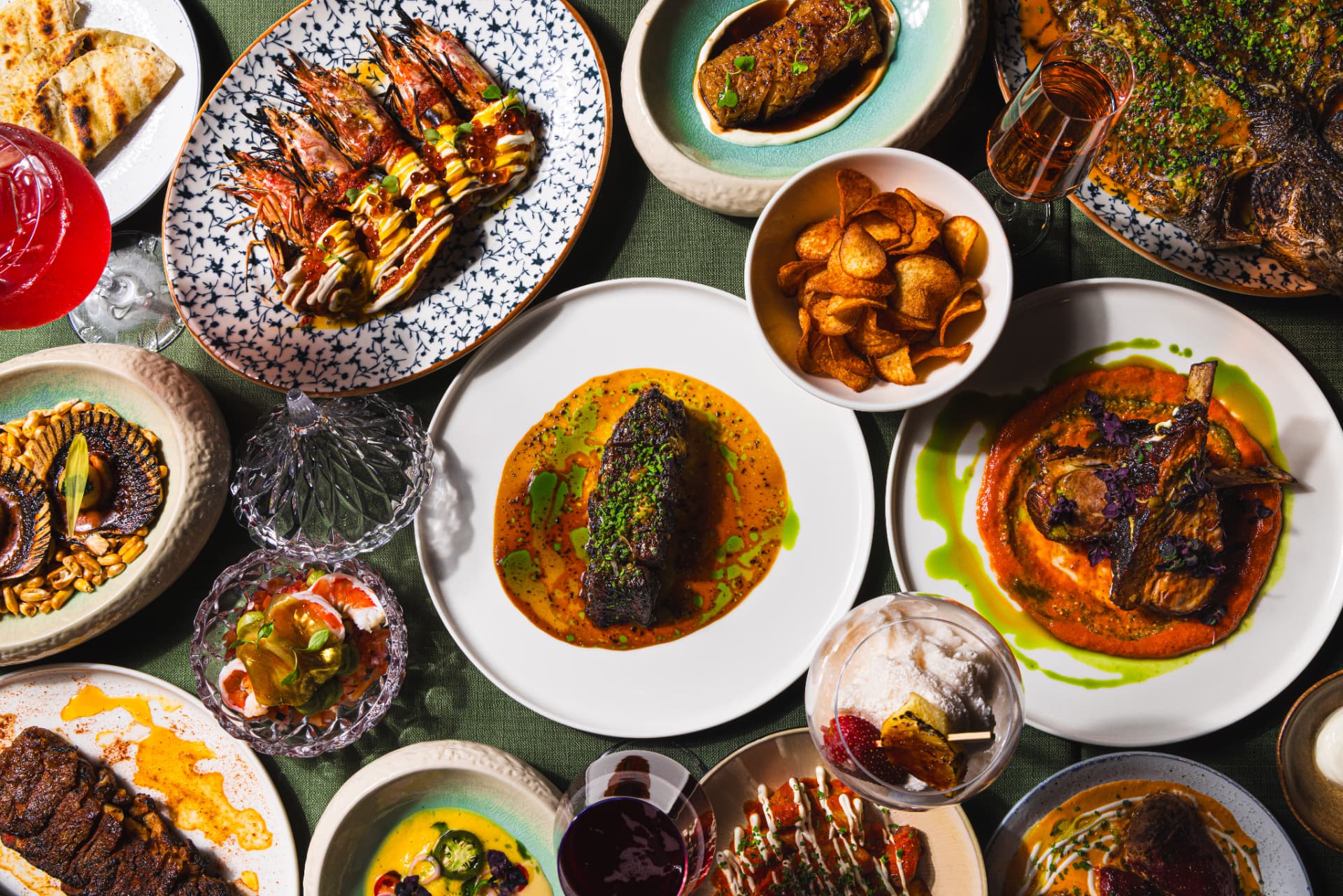 Overhead flatlay of dry-aged meat and seafood dishes at The Margin