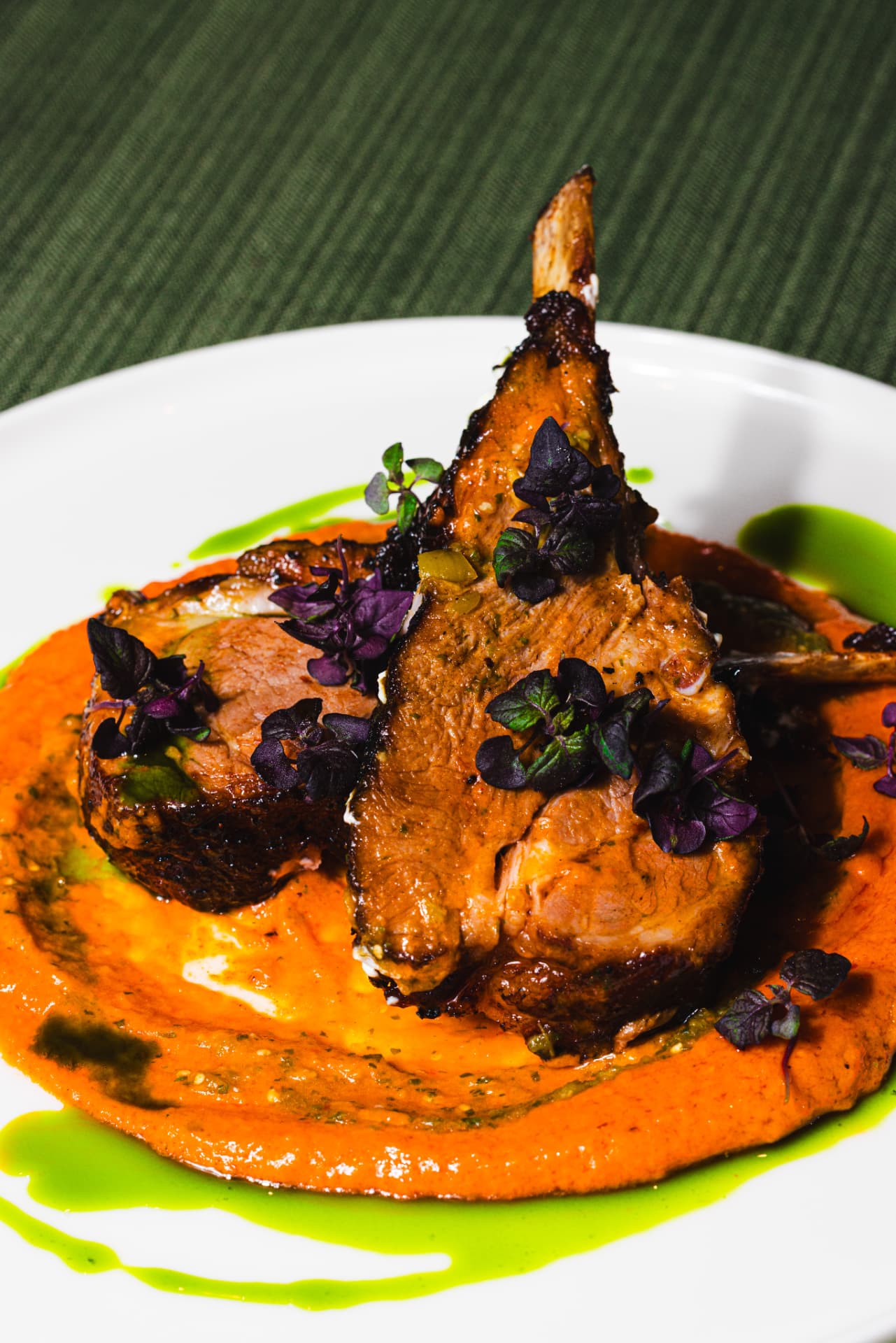 Roasted lamb rack on romesco with basil oil and purple shiso at The Margin