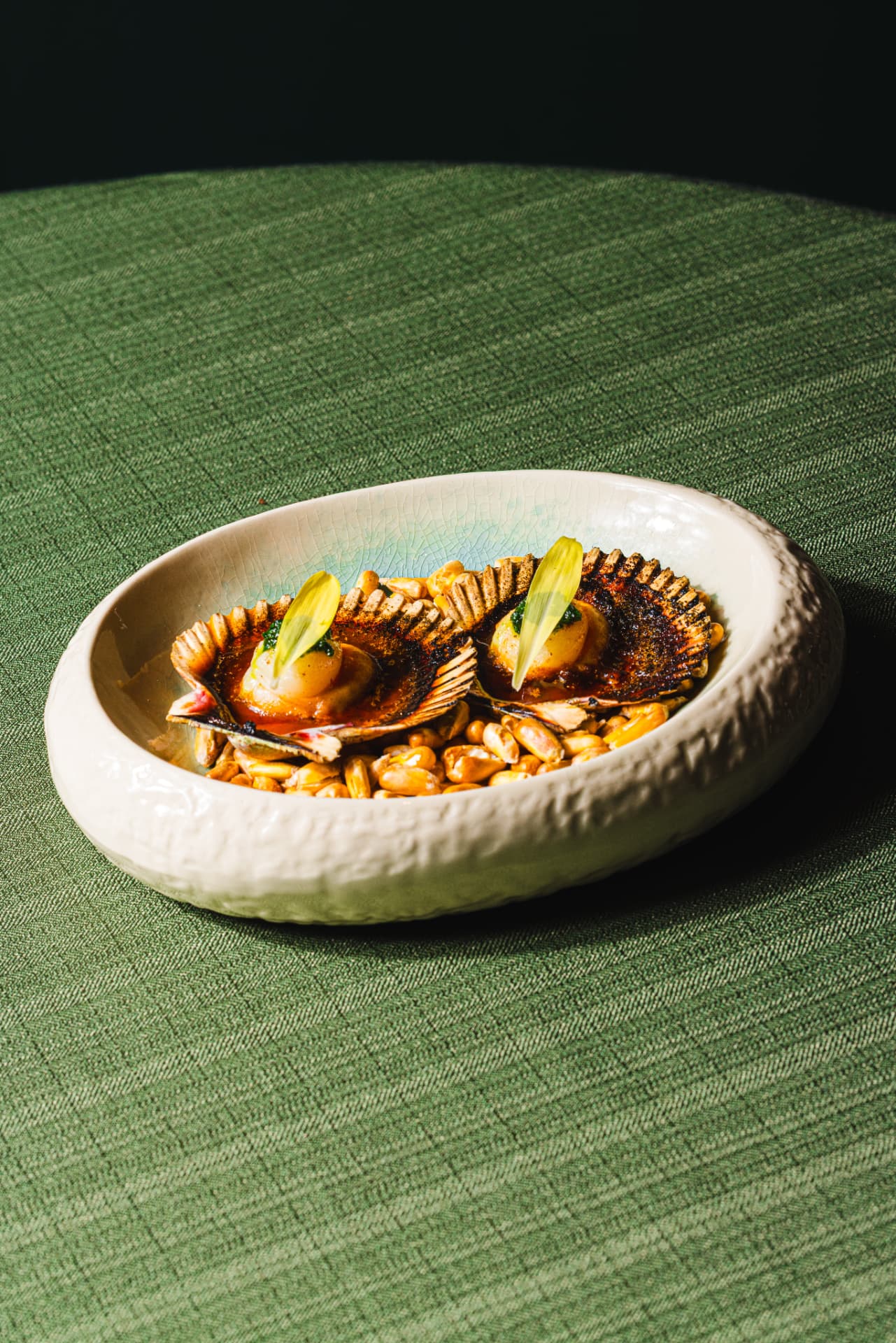 Grilled scallops in the shell with charred corn and herb oil at The Margin